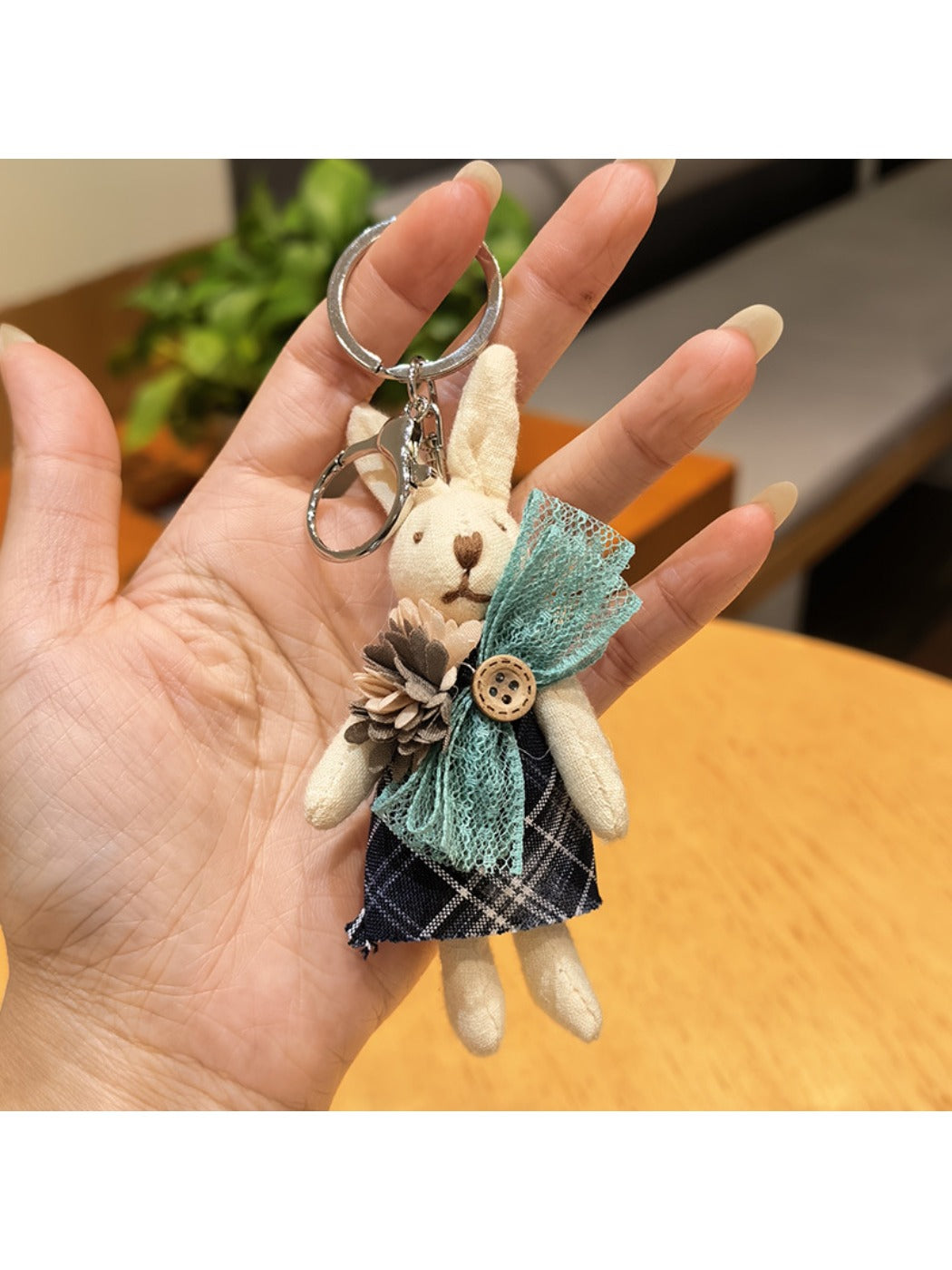 Rabbit charm keychain hanging from a decorative hook on a wall