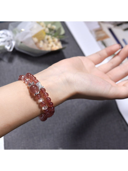 Lovra bracelet wrapped multiple times around wrist showcasing pink strawberry quartz stones