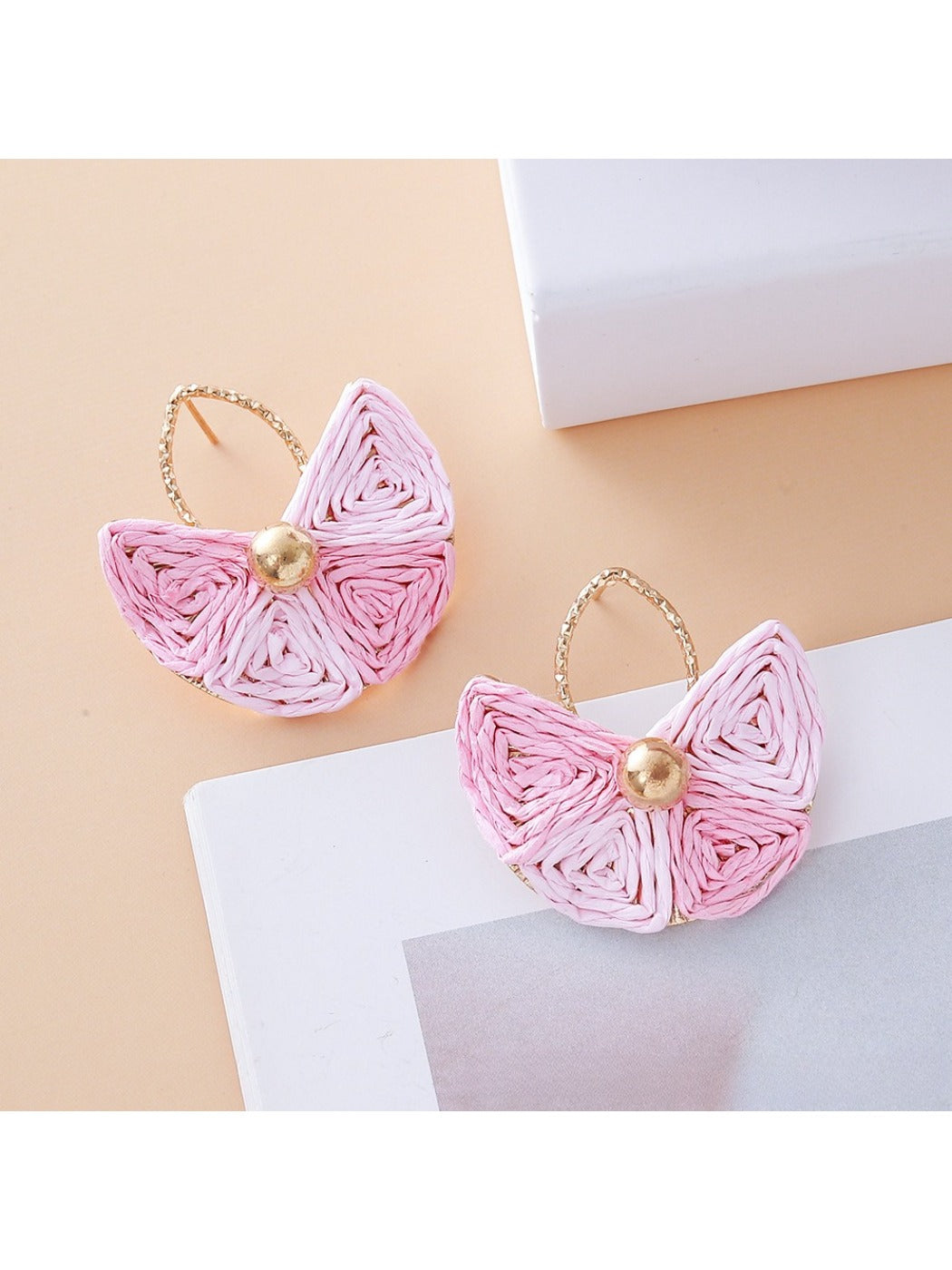 Detailed shot of raffia texture and gold hook on vintage fan shaped earrings