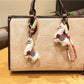 Alpaca charm keychain hanging from a silver keyring on a white background