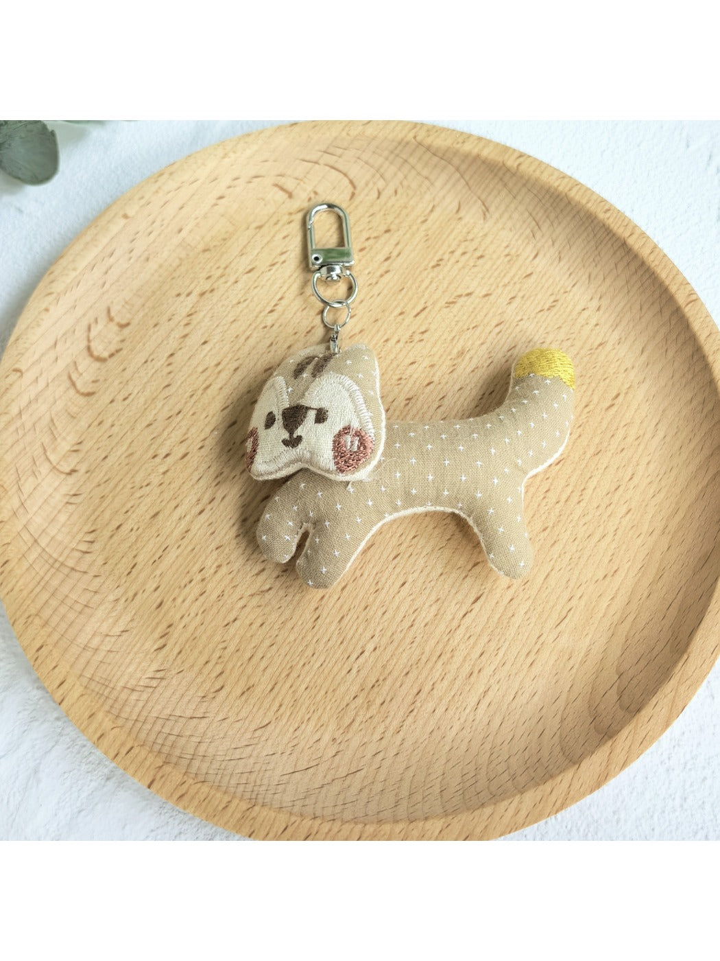 Keypus squirrel charm keychain photographed from above on a white surface