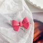 Beau delicate bow hair clip held in hand showing size and texture