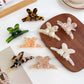 Beau minimalist hair claw clip with a delicate bow detail in neutral color
