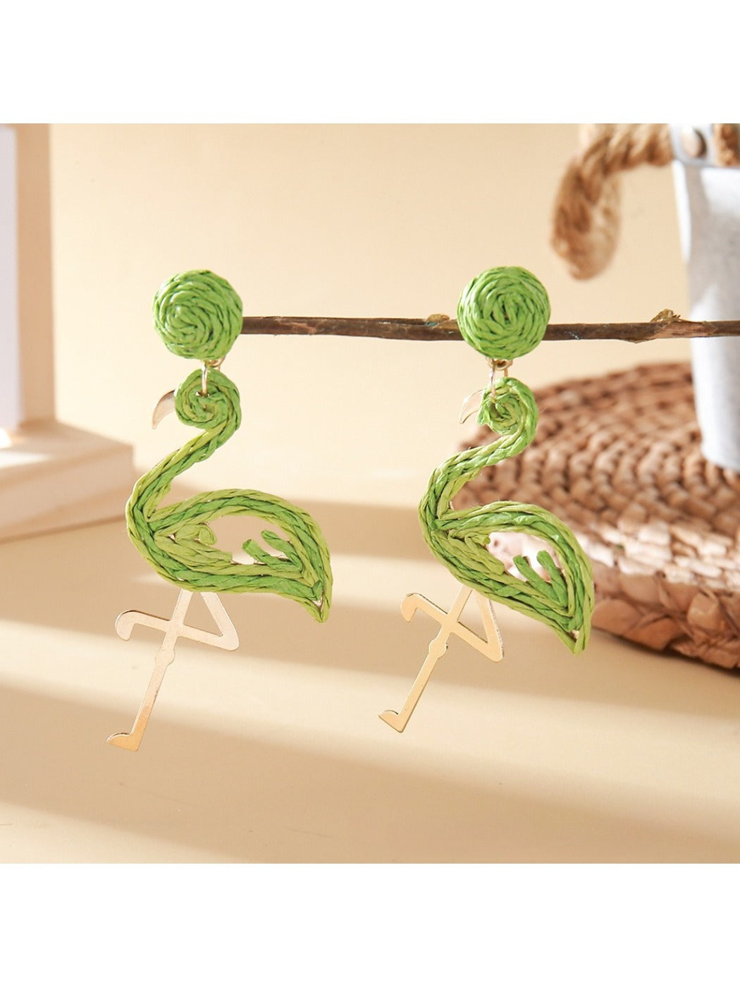 Detailed shot of the flamingo pendant earring showing pink enamel and metal details