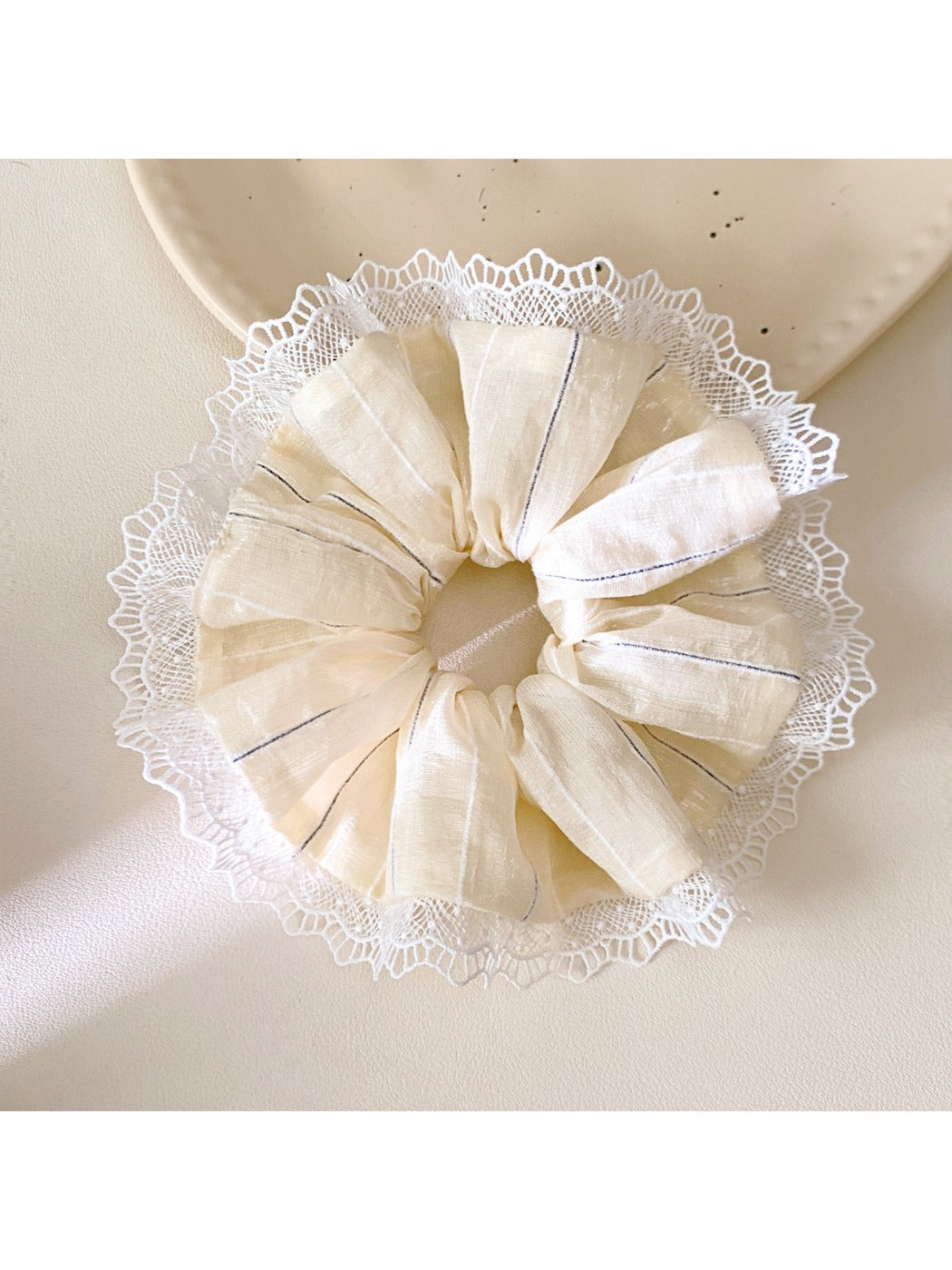 Gifty striped ruched scrunchie styled on a wrist as an accessory
