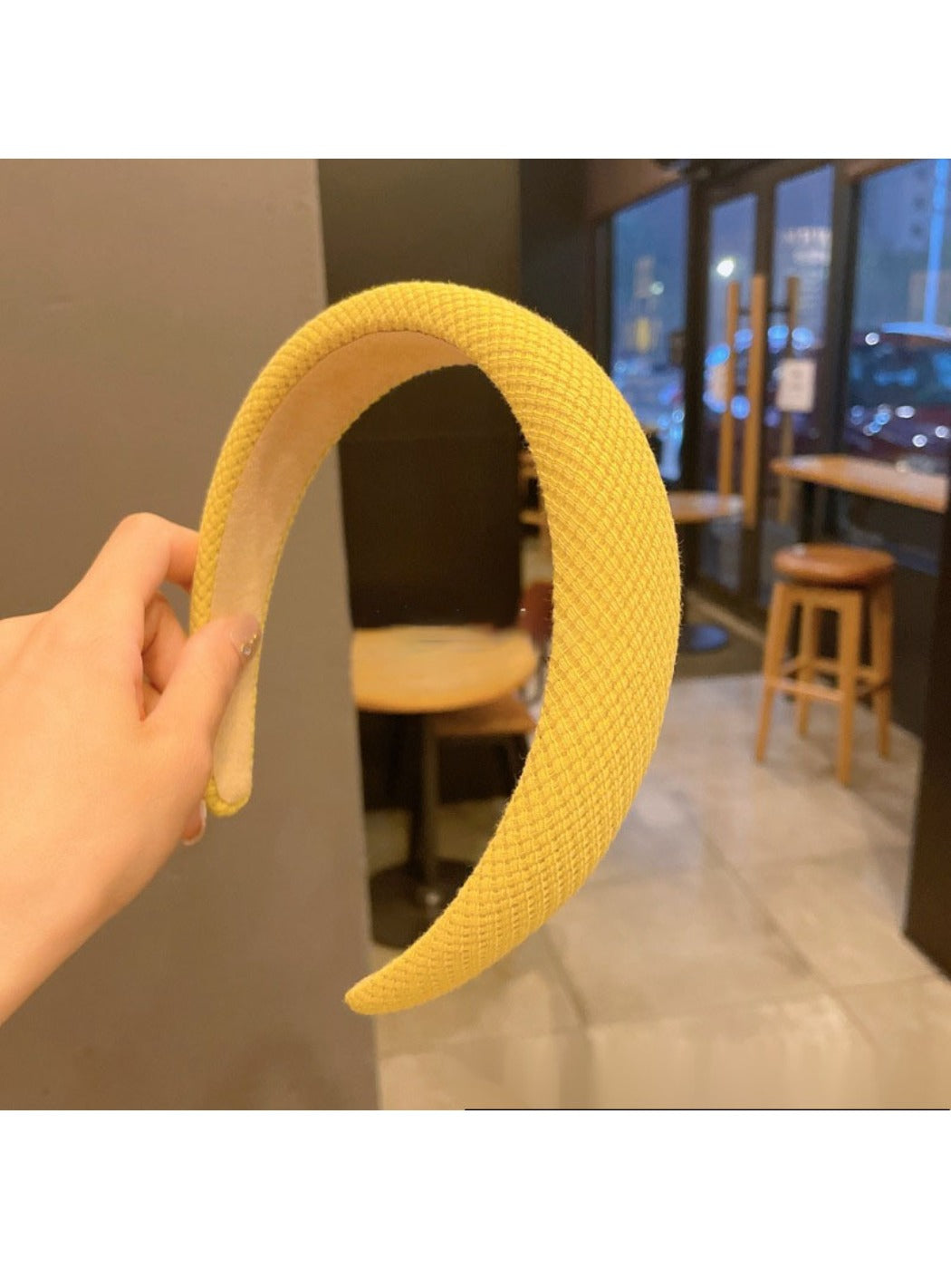 Yellow headband with bow placed flat on a wooden surface