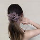 Close-up of ruffled edges on the solid color scrunchie showing fabric texture