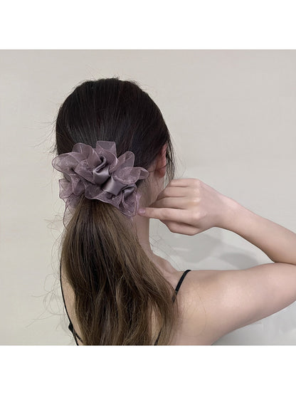 Close-up of ruffled edges on the solid color scrunchie showing fabric texture