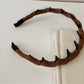 Solid color corduroy headband in muted pink with gathered elastic back