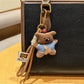 Fabric bear keychain displayed with other small accessories on a table