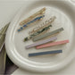 Beau hair clip held in hand displaying size and tortoiseshell acetate design