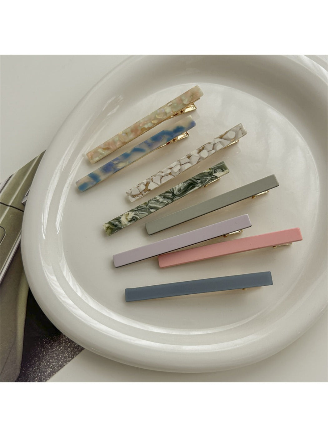 Beau hair clip held in hand displaying size and tortoiseshell acetate design