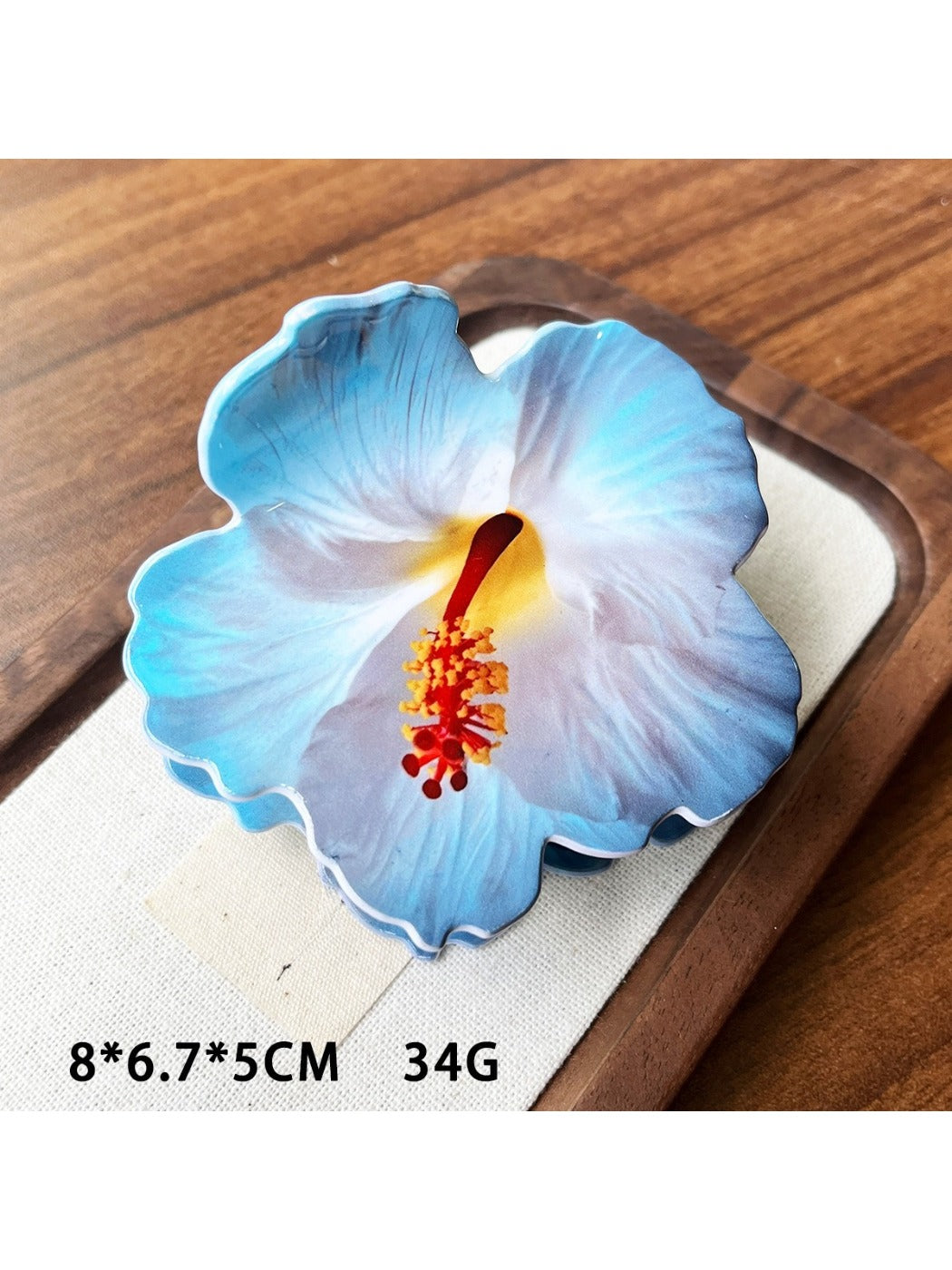 Beau hibiscus claw clip packaged in clear plastic box with branding