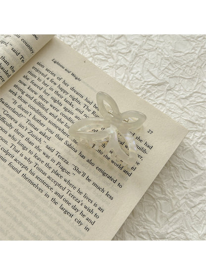 Beau acetate butterfly claw clip with light reflecting off glossy surface