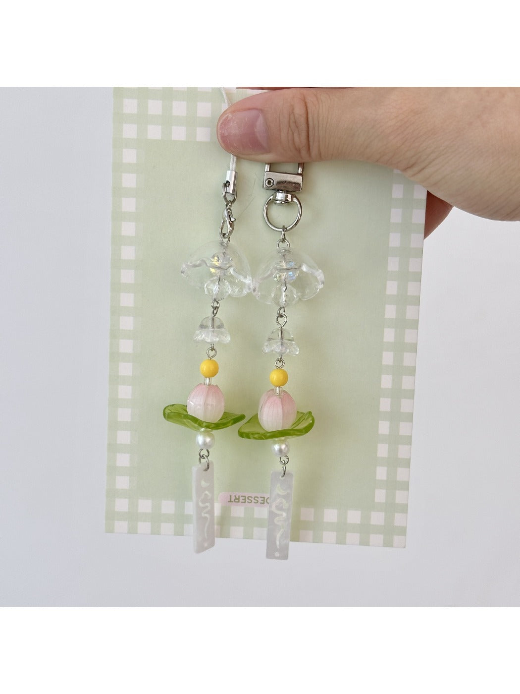 Close-up of lotus wind chime keychain showing detailed metalwork and hanging bells