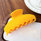 Beau Candy Polka Dot acetate claw clip placed on wooden surface