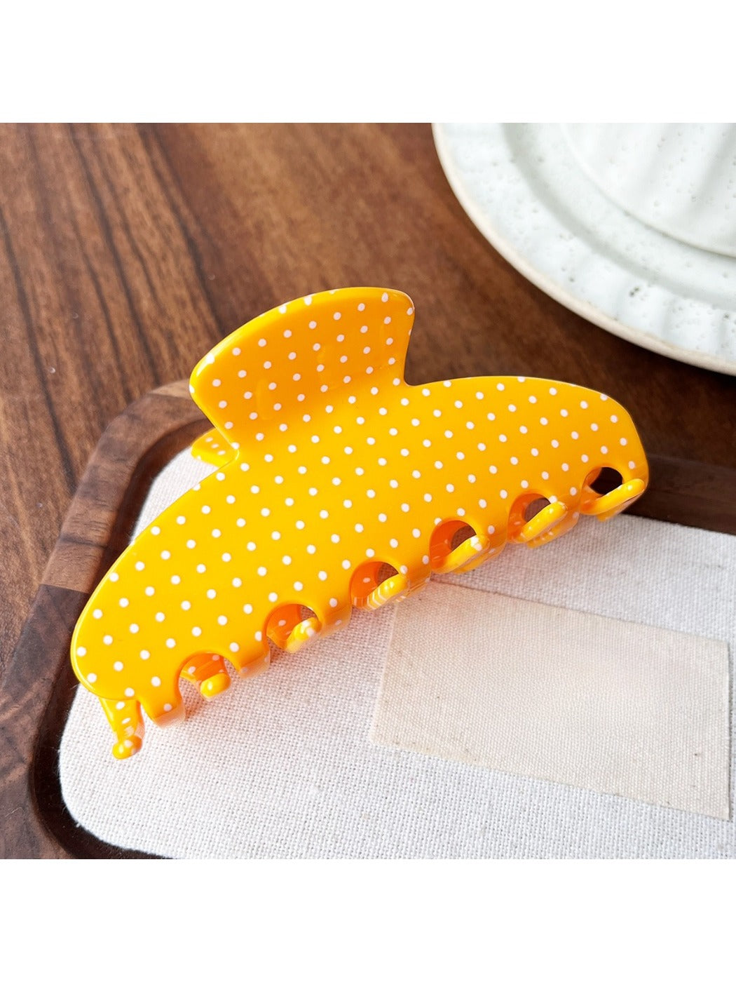 Beau Candy Polka Dot acetate claw clip placed on wooden surface