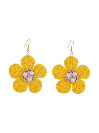 Top view of raffia flower earrings emphasizing the circular woven pattern and gold backing