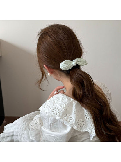 Top view of Gifty plaid hair tie featuring a red bow and elastic band