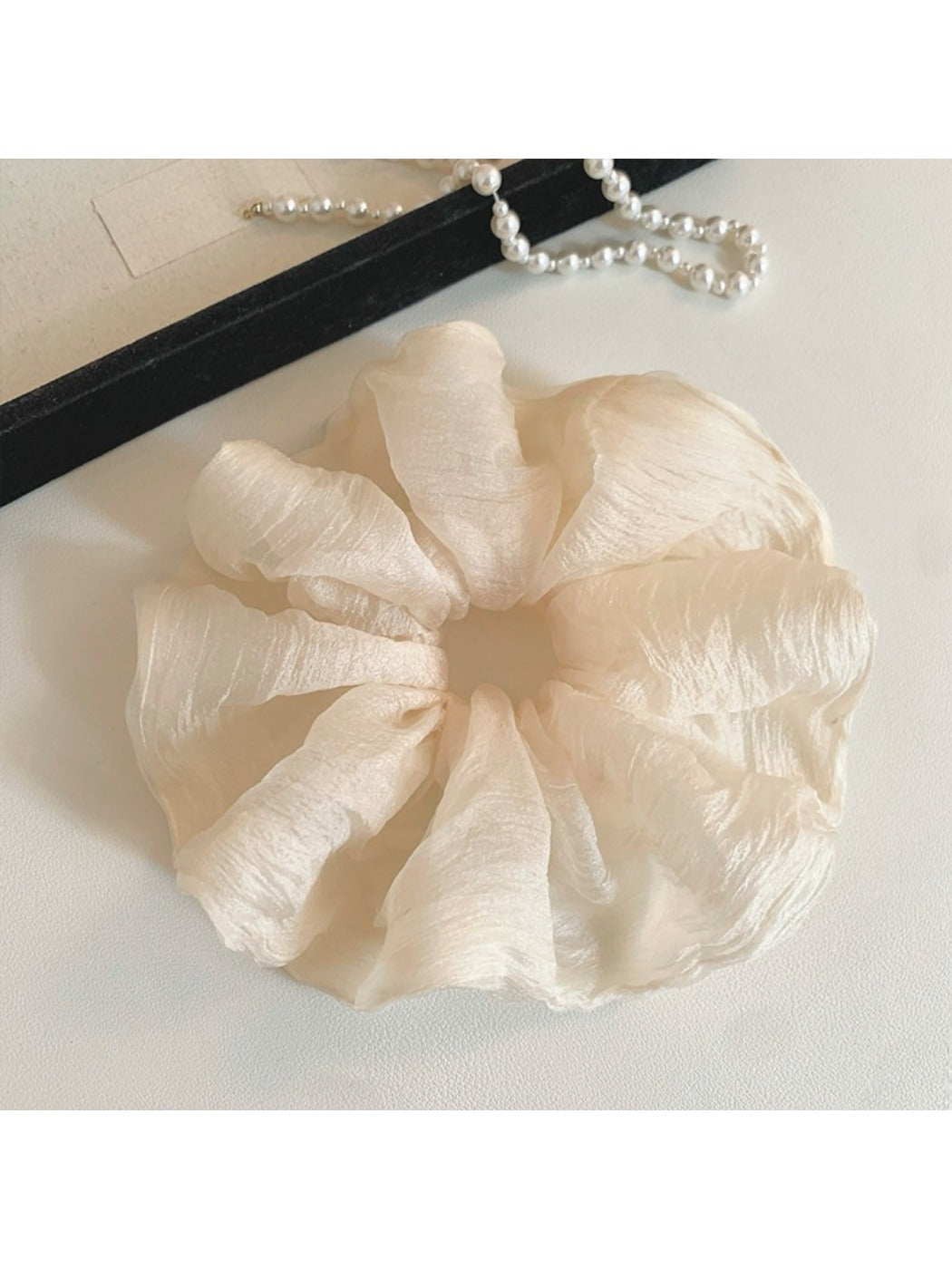 Minimalist scrunchie displayed flat showing its thin, solid color design