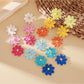 Close-up of colorful flower shaped drop earrings with multiple petals
