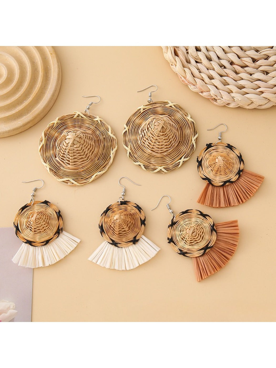 Close-up of Earedge straw hat shaped earrings on white background