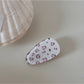Beau hair clip positioned next to vintage jewelry pieces, enhancing its sophisticated look