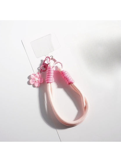 Keypus keychain with vibrant flower design hanging from a bag zipper