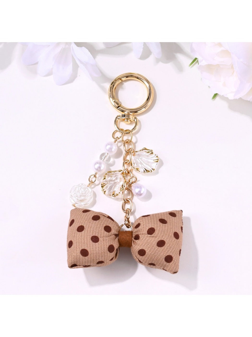 Rose-shaped pendant keychain attached to a set of keys on a wooden surface