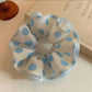 Close-up of Gifty polka dot scrunchie in black and white fabric