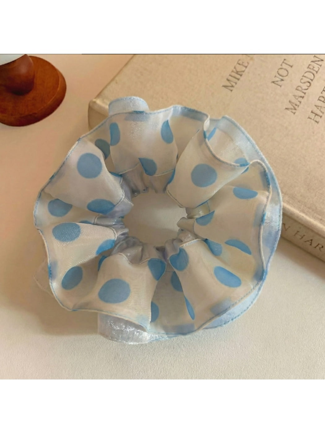 Close-up of Gifty polka dot scrunchie in black and white fabric