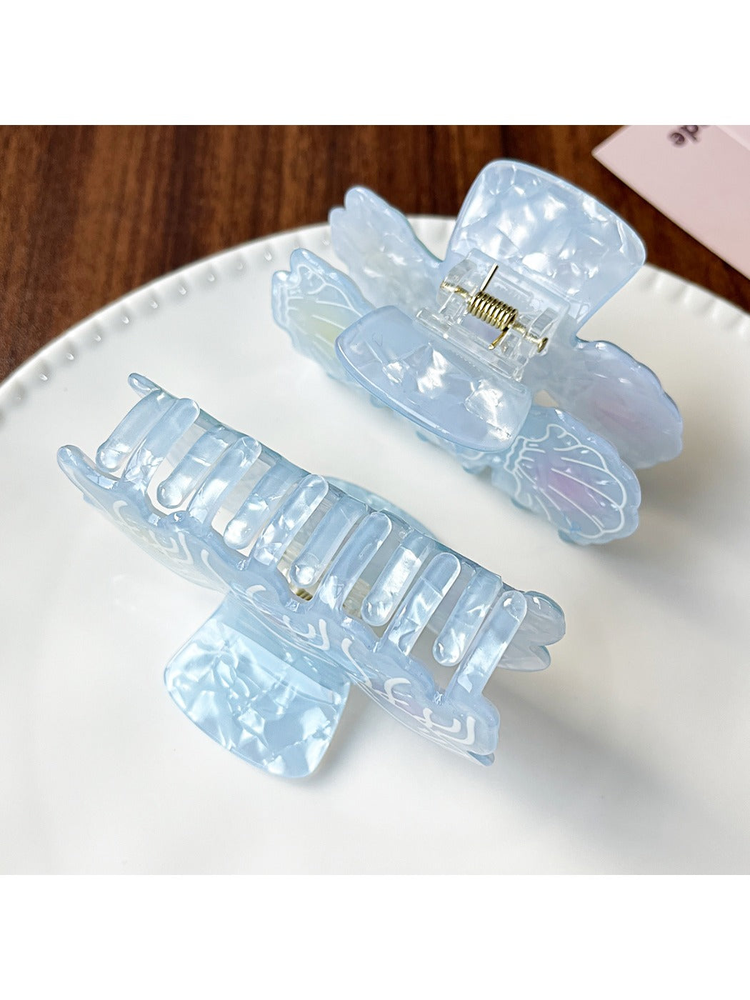 Beau claw clip open displaying spring hinge and gradient blue color