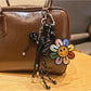 Close-up of rainbow sunflower keychain showing detailed petal texture and gold ring