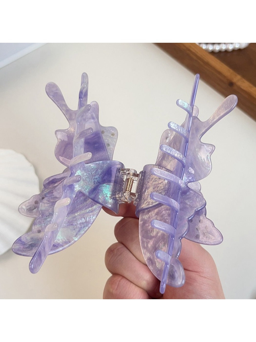 Side view of colorful butterfly hair claw clip highlighting wing shape