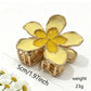 Beau flower hair clip with layered fabric petals and shiny gold center detail