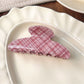Beau pink plaid crescent claw clip displayed on a flat surface