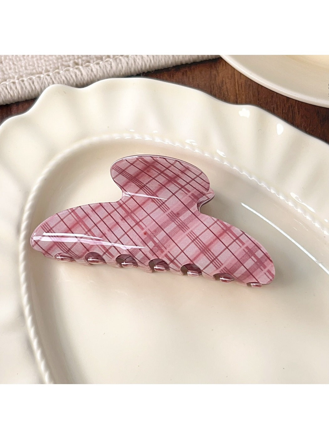 Beau pink plaid crescent claw clip displayed on a flat surface