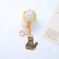 Cartoon cat piano keychain hanging from a set of keys on a keyring