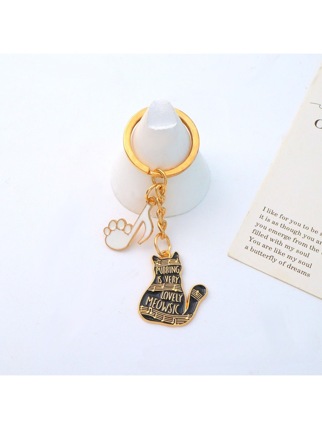 Cartoon cat piano keychain hanging from a set of keys on a keyring