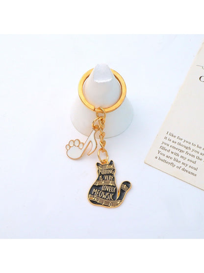 Cartoon cat piano keychain hanging from a set of keys on a keyring