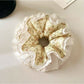 Side view of Gifty vintage floral ruched scrunchie showing fabric texture and elastic