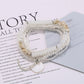 Lovra bracelet displayed flat with multiple rows of bright beads and gold elements
