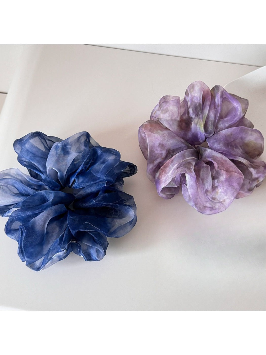 Multi color tulle scrunchie with layered pastel shades on a white background