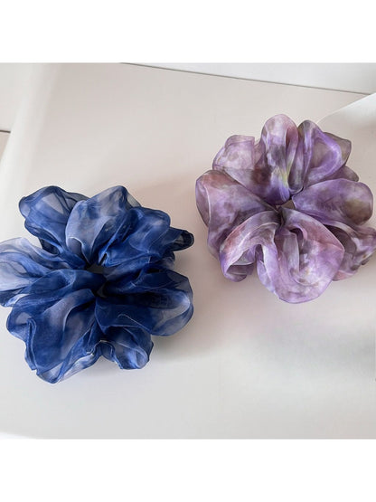 Multi color tulle scrunchie with layered pastel shades on a white background