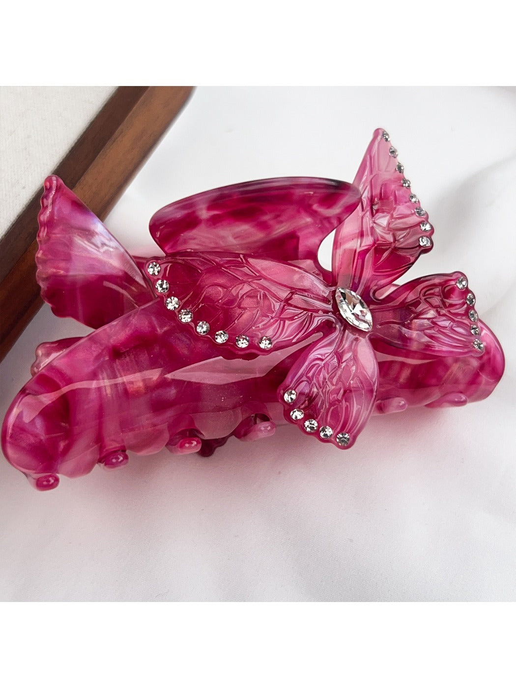 Beau hair claw clip with multicolored butterfly decorations in natural light