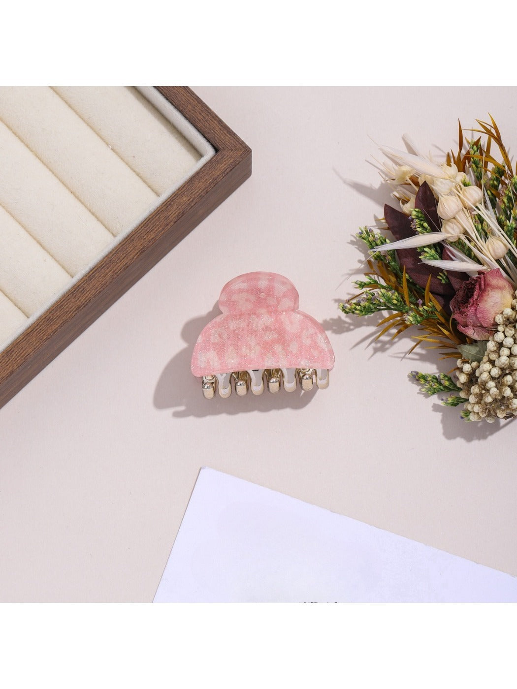 Beau hair clip with leopard print pattern placed on wooden surface