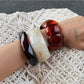 Lovra bracelet styled on wrist with layered jewelry and casual outfit