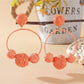 Earedge raffia round ball earrings worn on a model's ear