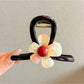 Beau pink flower claw clip styled in a woman's hair