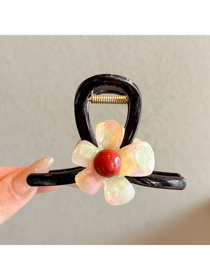 Beau pink flower claw clip styled in a woman's hair